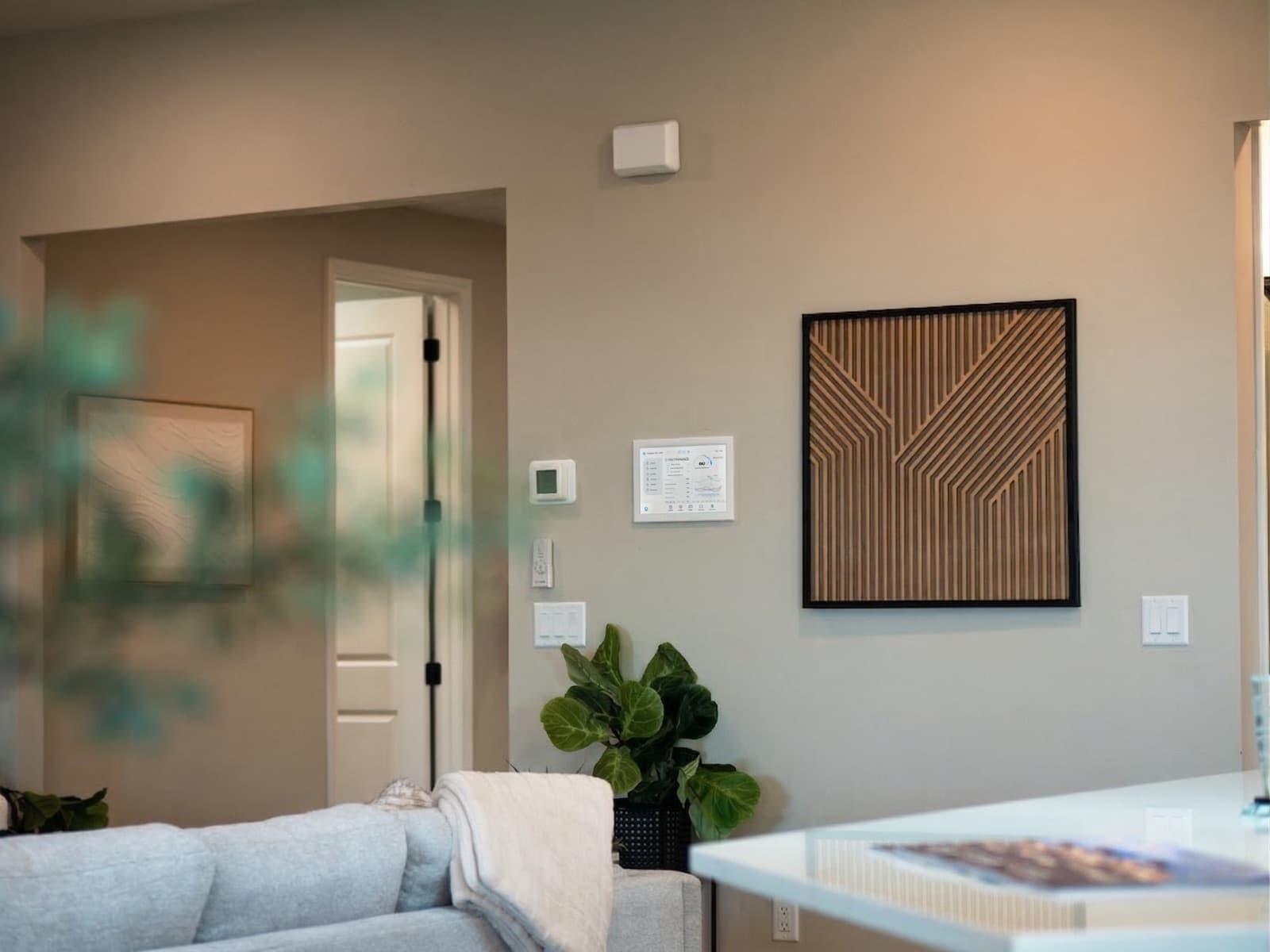 Abrazo Intelligence wall tablet and thermostat in a finished living room